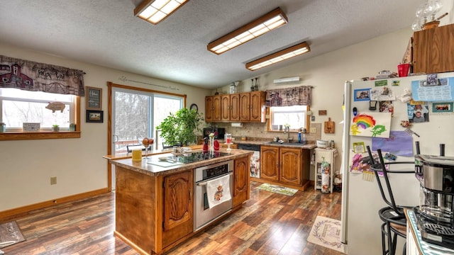 1295 Maple Brook Rd, New Concord, OH 43762 - kitchen with black electric stovetop, lofted ceiling, stainless steel oven, freestanding refrigerator, and brown cabinetry