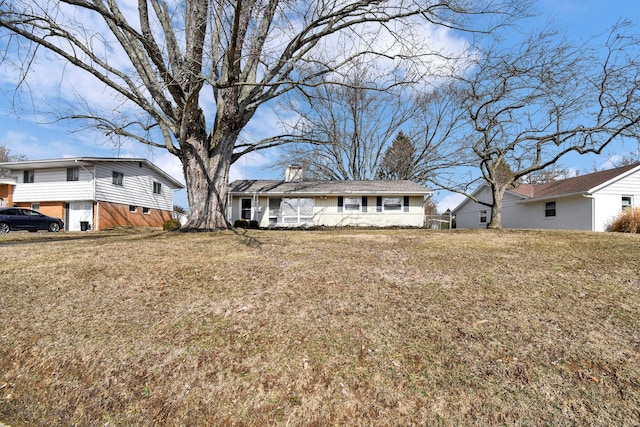 view of front of home with a chimney and a front yard