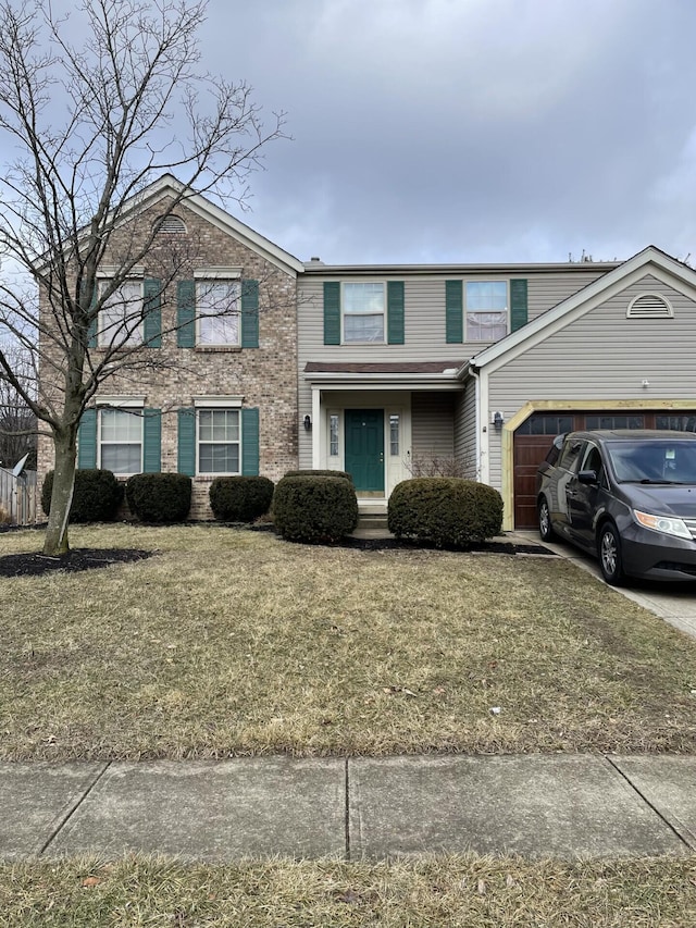 traditional home with a garage, driveway, brick siding, and a front yard