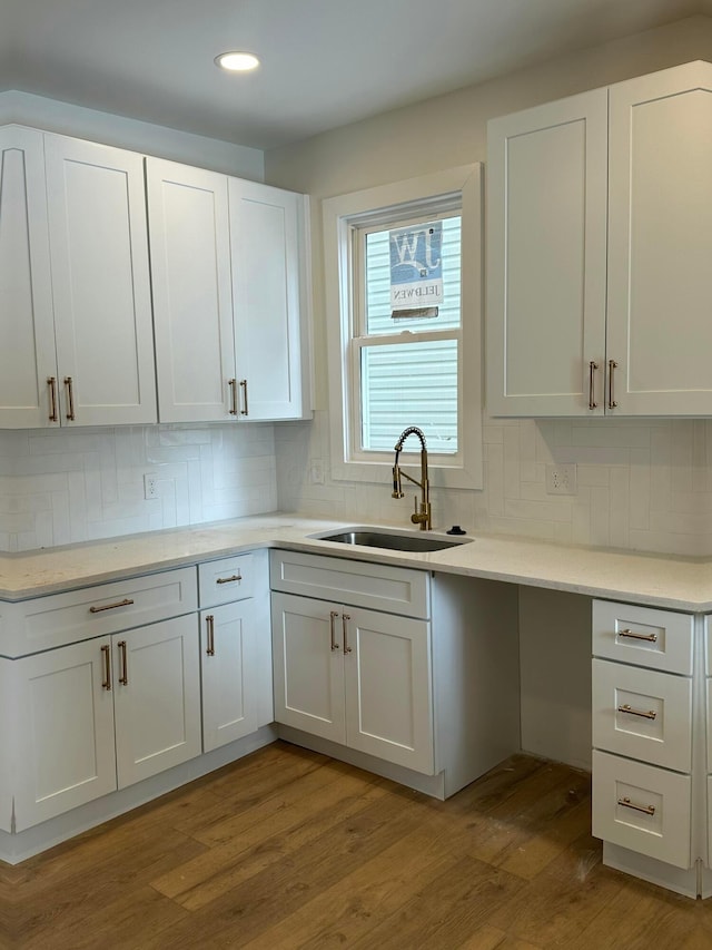 kitchen with light countertops, a sink, and white cabinets