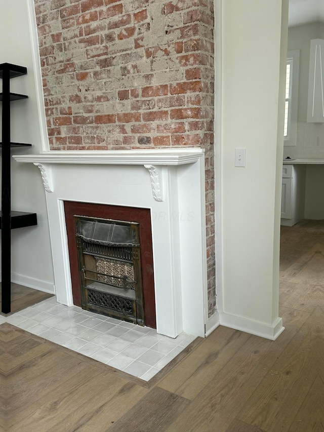 room details with a fireplace, wood finished floors, and baseboards