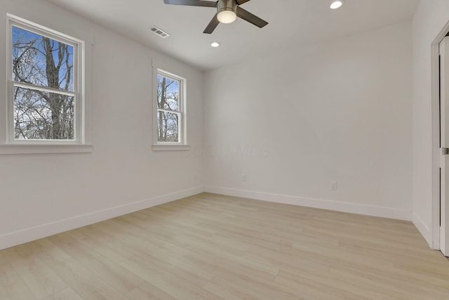 empty room with recessed lighting, visible vents, light wood-style floors, a ceiling fan, and baseboards