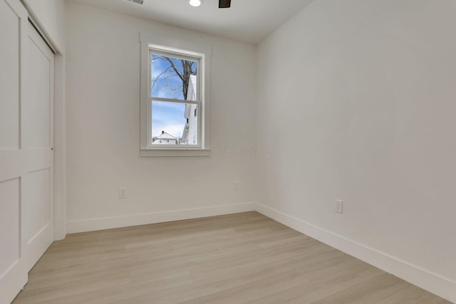 interior space with light wood-style floors, a closet, baseboards, and a ceiling fan