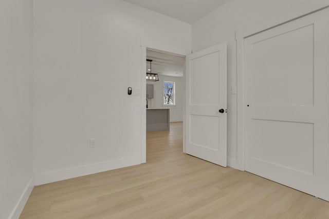 spare room featuring light wood-type flooring and baseboards