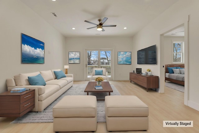 living room with light wood-style floors, ceiling fan, visible vents, and recessed lighting