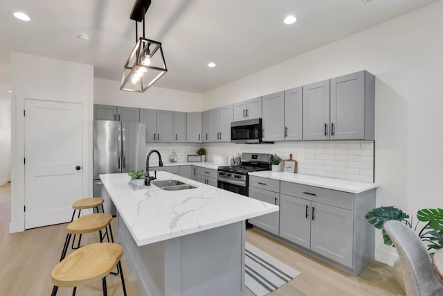 344 Buckingham St, Newark, OH 43055 - kitchen with stainless steel appliances, gray cabinets, a sink, light wood finished floors, and decorative backsplash