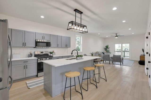 344 Buckingham St, Newark, OH 43055 - kitchen with stainless steel appliances, a sink, gray cabinets, tasteful backsplash, and a breakfast bar area