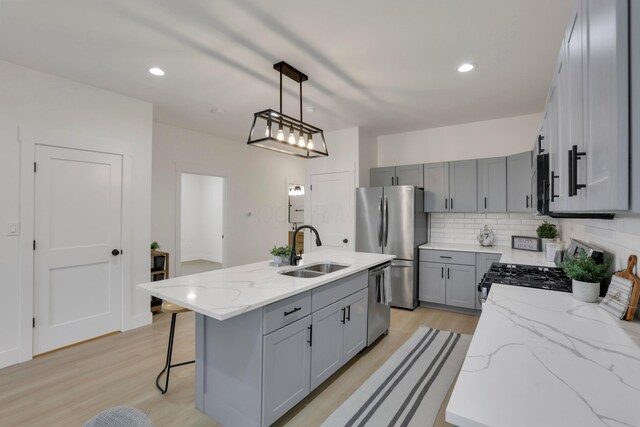 344 Buckingham St, Newark, OH 43055 - kitchen featuring a sink, gray cabinets, appliances with stainless steel finishes, backsplash, and light wood-type flooring