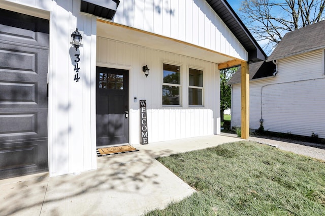 344 Buckingham St, Newark, OH 43055 - doorway to property with board and batten siding, a yard, and a garage