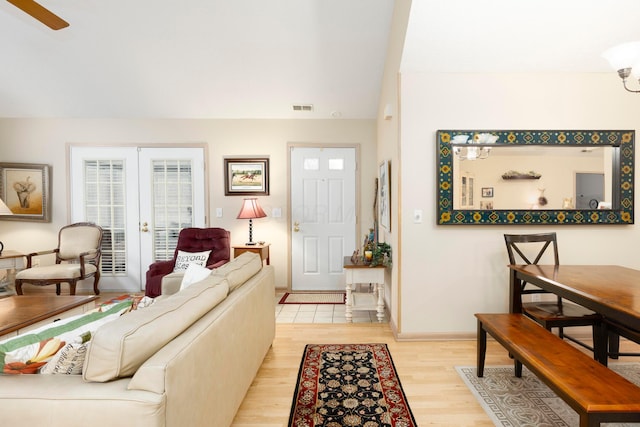 living room featuring light wood-style flooring, visible vents, baseboards, and french doors