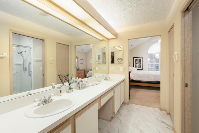 ensuite bathroom featuring a sink, marble finish floor, double vanity, and ensuite bath