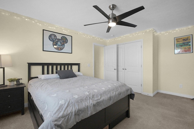 bedroom with a ceiling fan, baseboards, a closet, and light colored carpet