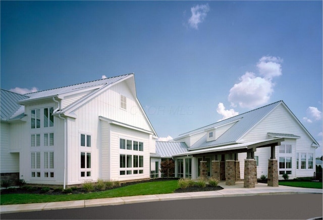 rear view of house featuring a standing seam roof, metal roof, and board and batten siding