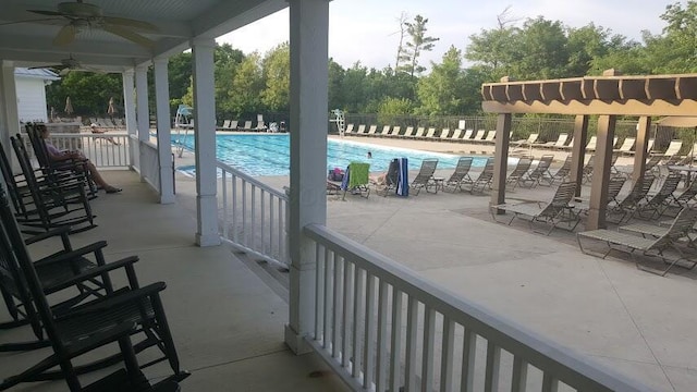 community pool featuring fence, a ceiling fan, and a patio