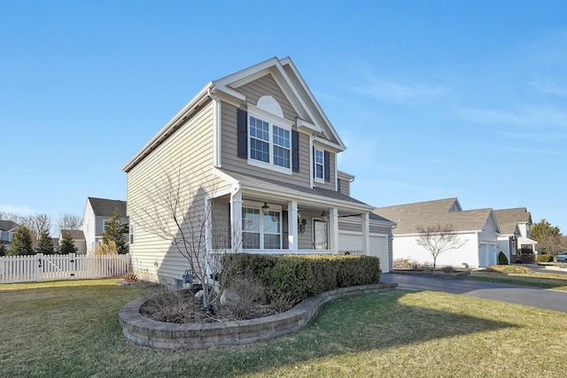 traditional-style home featuring an attached garage, driveway, a front yard, and fence