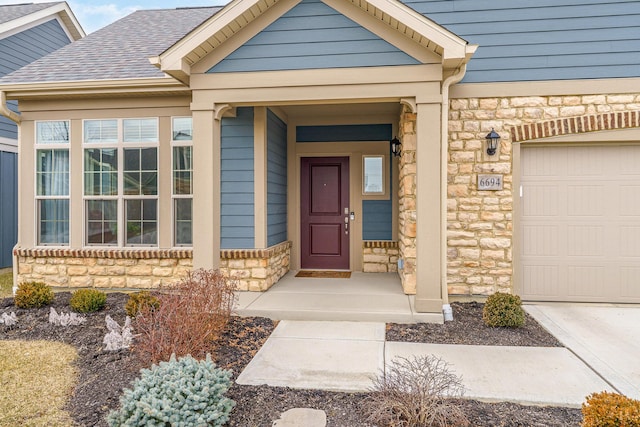 doorway to property with stone siding, roof with shingles, and an attached garage