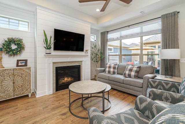 living room featuring hardwood / wood-style floors, a wealth of natural light, and a glass covered fireplace