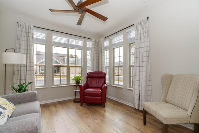 living area with hardwood / wood-style floors, a healthy amount of sunlight, and baseboards