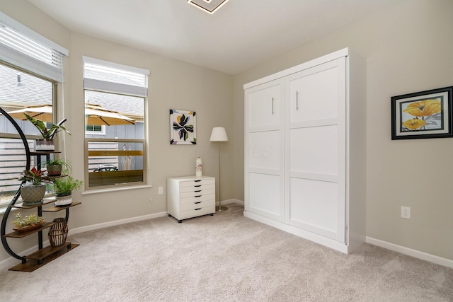 bedroom with baseboards and light colored carpet