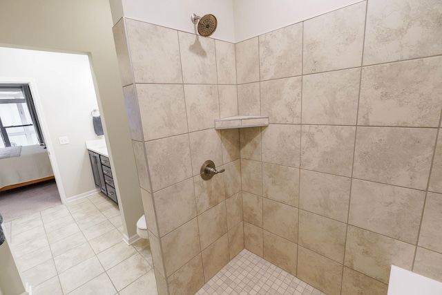 ensuite bathroom featuring connected bathroom, baseboards, tile patterned flooring, and a tile shower