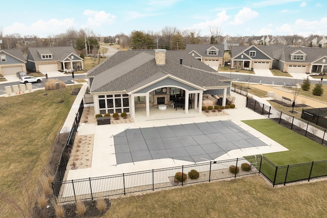 rear view of property featuring a patio, a fenced in pool, fence, roof with shingles, and a residential view