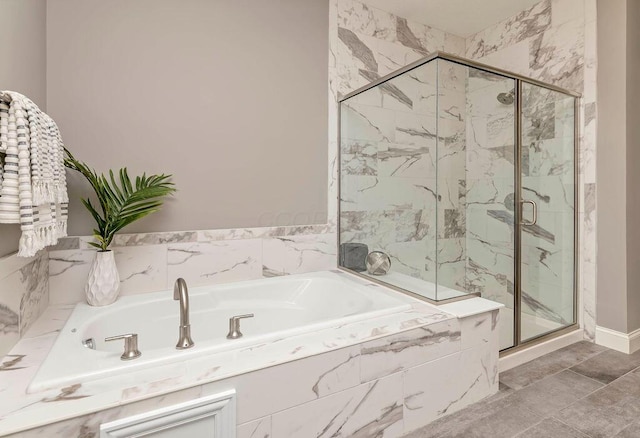 bathroom featuring a garden tub and a marble finish shower