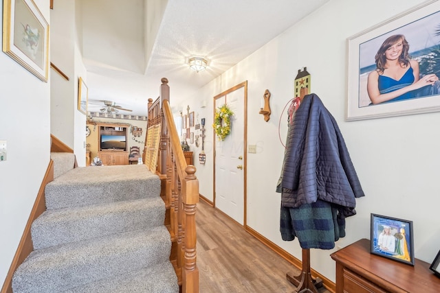 staircase with baseboards and wood finished floors