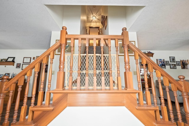 staircase with a textured ceiling