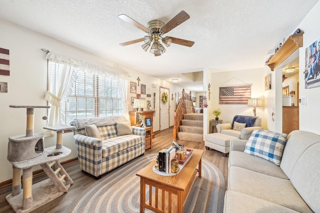 living room with stairs, a textured ceiling, and wood finished floors