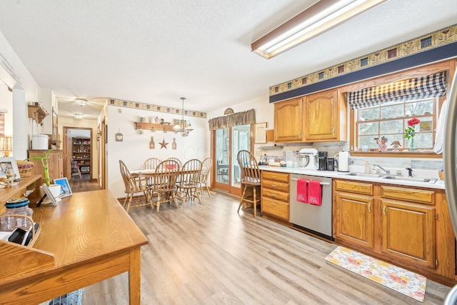 kitchen with plenty of natural light, light countertops, a sink, and stainless steel dishwasher