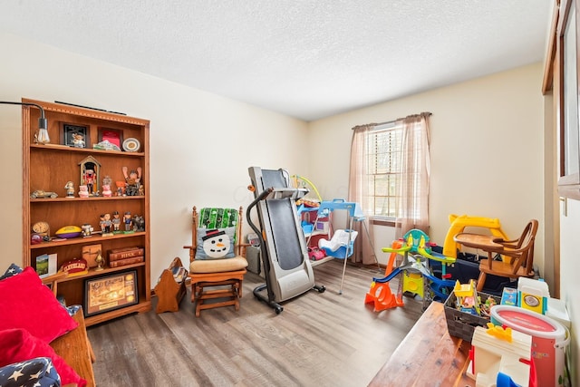 rec room with a textured ceiling and wood finished floors