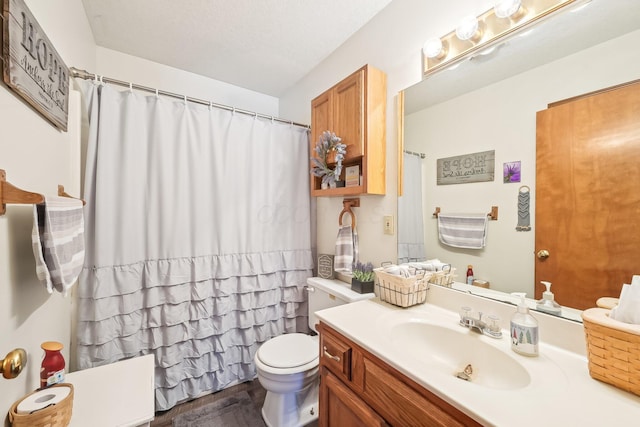 full bathroom featuring a shower with shower curtain, vanity, and toilet