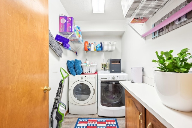 laundry room featuring light wood-type flooring, washer and dryer, and laundry area