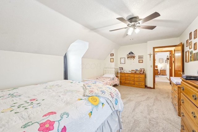 bedroom with a ceiling fan, lofted ceiling, light colored carpet, and a textured ceiling