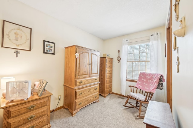 sitting room featuring baseboards and light colored carpet