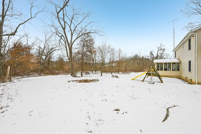 yard covered in snow featuring a sunroom