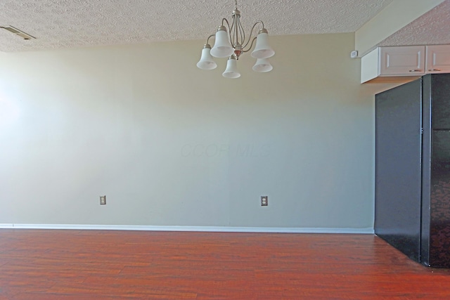 unfurnished dining area featuring baseboards, visible vents, and wood finished floors