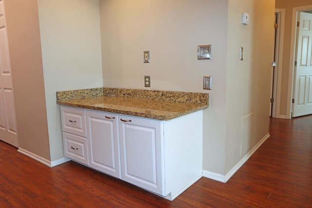 kitchen featuring light stone countertops, white cabinetry, and dark wood-style flooring