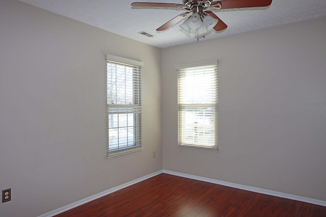 empty room with a ceiling fan, a textured ceiling, baseboards, and wood finished floors