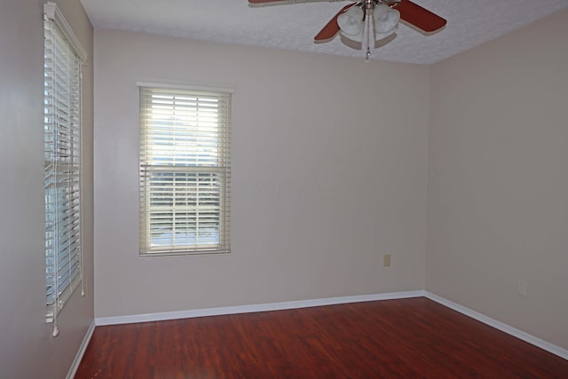 empty room featuring ceiling fan, a textured ceiling, baseboards, and wood finished floors