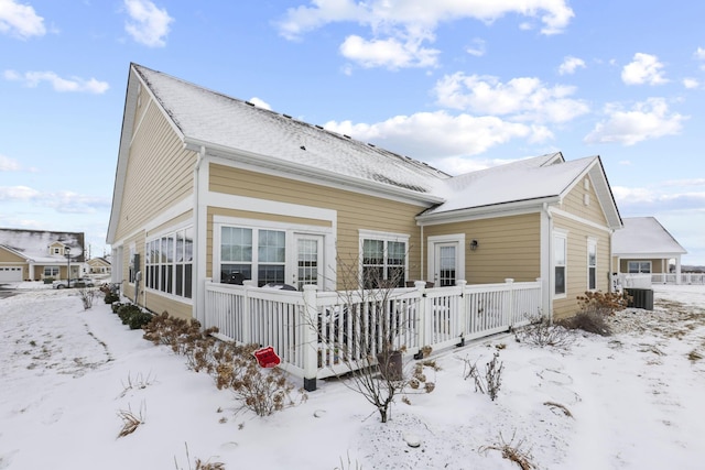 snow covered property with central AC