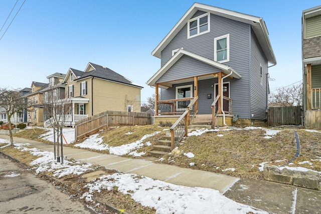 view of front of property with a residential view, covered porch, and fence