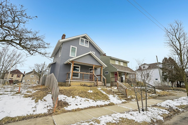 view of front of property featuring covered porch, a chimney, and a residential view