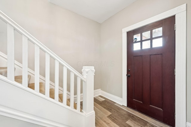 entryway with stairs, light wood finished floors, and baseboards