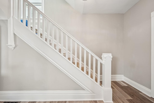 stairs featuring wood finished floors and baseboards