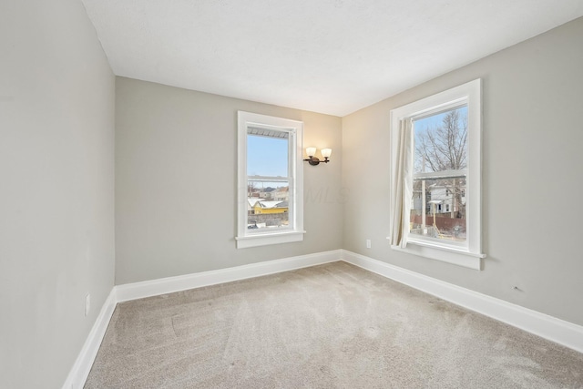 unfurnished room with carpet and baseboards