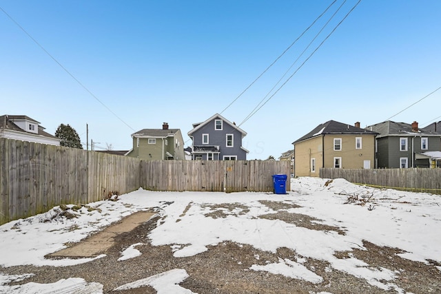 snowy yard with a fenced backyard and a residential view