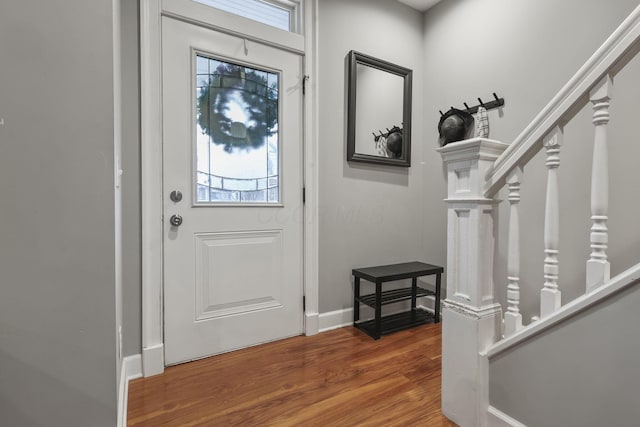 entrance foyer featuring wood finished floors, baseboards, and stairs