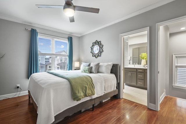 bedroom with crown molding, ensuite bath, wood finished floors, and baseboards