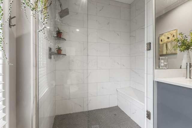 bathroom featuring a tile shower and vanity